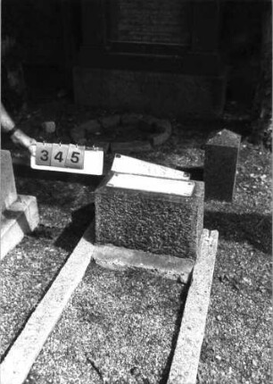 Grabstein 345 (Index: 99797189) Material: Granit Zustand: umgestürzt, beschädigt Maße HxBxT: 96x41x14 cm Beschreibung: Stele, Sockel, Segmentbogenabschluß: Grabstein 345