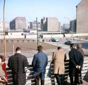 Berlin. Mauerblick ins versperrte Ost-Berlin : Berlin. Westberliner Passanten blicken von einer Tribüne über die Mauer nach Ost-Berlin