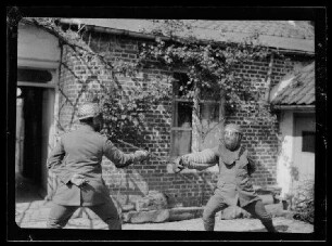 Florettfechten vor einem Hauseingang in Guillemont (Dep. Somme, Frankreich)
