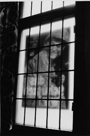 Blick durch ein mit einem Plakat beklebtes Fenster