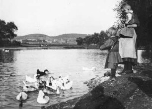 Coswig. Mutter mit zwei Kindern beim Füttern von Enten am Dorfteich
