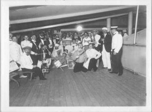 Hochseepassagierdampfer Cleveland, Bordaufnahmen. Gruppenbild mit kostümierten Touristen und Katzen in Tierkäfigen während eines Bordfestes