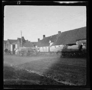 [Fresnes-les-Montauban (Dep. Pas-de-Calais, Frankreich):] Verbandplatz des 3. Bataillons des 2. Reserve-Infanterie-Regiments an einer morastigen Ortstraße, im Vordergrund 4 Einspänner mit beladenen Wagenkarren
