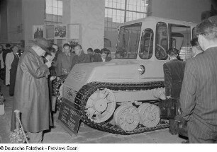Besucher vor einer Raupe in der sowjetischen Ausstellungshalle