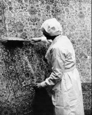 Frau beim Teppich reinigen