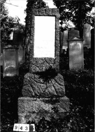 Grabstein 943 (Index: 99802624) Material: Granit mit Marmorplatte Zustand: gut Maße HxBxT: 208x69x43 cm Beschreibung: getreppter Sockel, Stele mit horizontalem Abschluß, Inschriftenplatte: Grabstein 943
