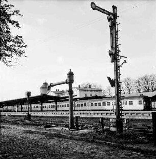 Bahnsteig mit wartendem Personenzug: im Hintergrund Bahnhofsgebäude: im Vordergrund Signal, Pumpe