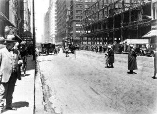 Die Michigan Avenue : Blick in eine Straße mit Hochhäusern, Personen und Automobilen