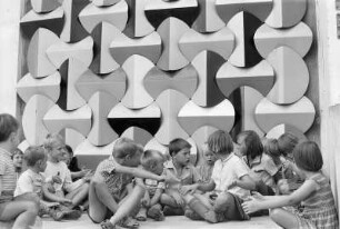 Eine Gruppe von Kindern auf der Straße in einem Neubaugebiet sitzend, Halle-Neustadt