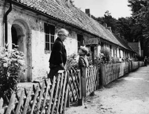 Ahrensburg. Idyllische Reihenhäuser, sogenannte "Gottesbuden". Eine Frau steht mit einem Kind im Vorgarten