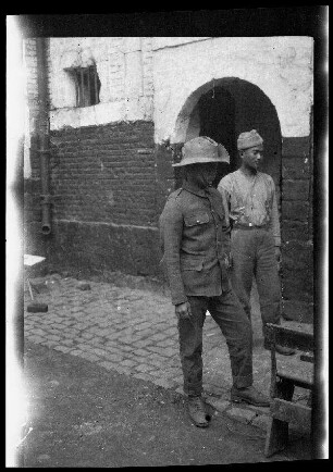 Lille (Dep. Nord, Frankreich): 2 Gefangene in einem gepflasterten Hof vor einem Mauertor ("Einbringen von Gefangenen auf der Zitadelle Lille")