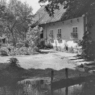 Strohgedecktes Blockhaus in Leipe mit Anlegerstelle. : Ze słomu kryta kładźita chěža w Lipjem z přistawnišćom.