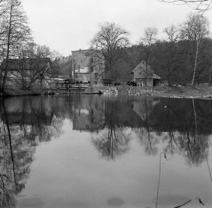Wolkenburg (Kreis Glauchau), Mühlenstraße 9. Gesamtansicht des Mühlenensembles, links Getreidemühle, rechts Sägemühle. Blick über die Zwickauer Mulde (nach rechts fließend) auf den Abzweig Mühlgraben mit Wehranlage