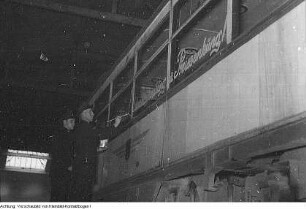 Dresden, VEB Verkehrsbetriebe der Stadt Dresden. Mitarbeiter beim Beschriften eines Straßenbahnwagens "Die Preissenkung - ein Erfolg unserer ...", Oktober/November 1953