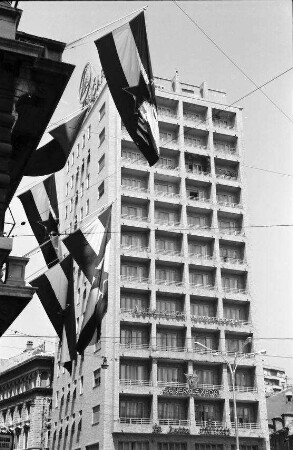 Rijeka: Hochhaus von unten mit Jugoslawischer Fahnen, am Narodni Trg