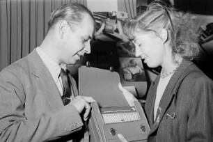 Leipziger Herbstmesse 1951 : Messebesucherin mit einem Kofferradio