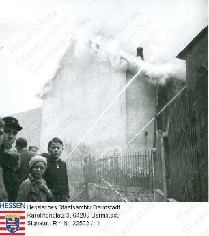 Ober-Ramstadt, 1938 November / Zerstörung und Brand der Synagoge / Feuerwehrmänner beim Sichern der Nachbarhäuser gegen einen Übergriff des Feuers, davor: schaulustige Kinder