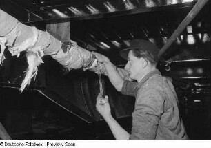 Arbeiter beim Abdichten von Rohren an einem Waggon
