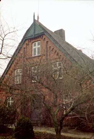 Sandweg 3: Fachwerkhaus mit Reetdach: Giebelseite Wohntrakt mit Lisenen, Gesims und Treppenzier, hölzerne Giebelzier