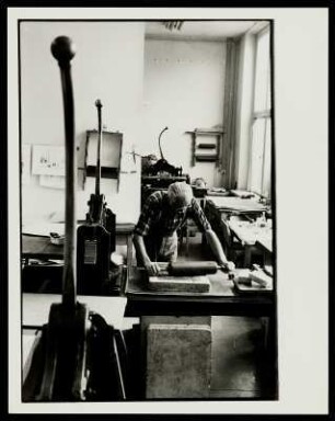 Ein Mann in einer Werkstatt bei der Herstellung einer Lithografie