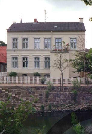Heiligengeiststraße 8: Traufseite: mit vorgebautem Eingangserker und Balkon: im Vordergrund Stadtarm der Trave, Ufermauer mit Treppe