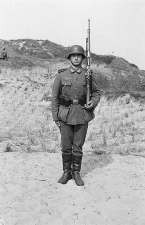 Zweiter Weltkrieg. Niederlande unter deutscher Besatzung. Angehöriger der deutschen Wehrmacht mit Gewehr in Dünen an der Nordsee (wohl bei Den Haag)