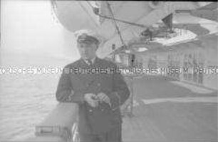 Offizier an Bord des Hochseepassagierdampfers "Bremen", an der Reling unter einem Rettungsboot stehend