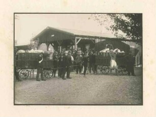 Kriegsgefangene an zwei Wagen mit Paketen stehend, im Hintergrund Baracke Kriegsgefangenlager Ludwigsburg-Eglosheim