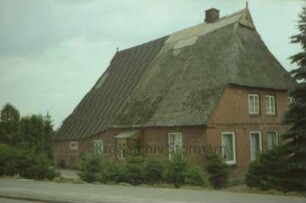 Benstaben: Fachwerkkate mit Reetdach: Traufseite, links Wirtschaftstrakt mit Blechdach, Eingangstür: rechts Giebelseite Wohntrakt
