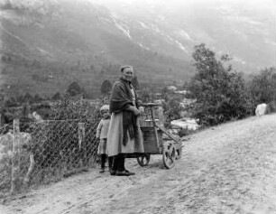 Großmutter und Enkelkind mit Leiterwagen unterwegs