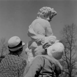 Dresden. Zwinger, zwei Besucherinnen betrachten die Skulptur eines Kindes, einen Delphin vor sich haltend