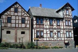 Wohnhaus mit Fachwerkschmuck, daneben Wirtschaftsgebäude