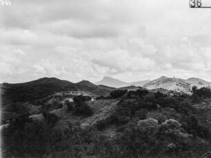 Landschaft : Blick von einer Anhöhe in das bewaldete Tal und auf die bergige Umgebung