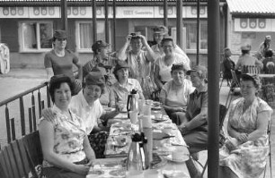 Plastex Ausflug. Hochformat 88 x 130 : VEB Plastex Delitzsch. Außensitzer einer Gaststätte. Gruppenbildnis der Plastex-Arbeiterinnen auf einem Ausflug, die an einer Kaffeetafel sitzend, mit Kuchen und Kaffee in Thermoskannen