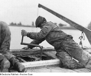 Deutschland . Nationale Volksarmee - Landstreitkräfte. Taktische Übung der Pioniertruppen. Pionier mit Steckschlüssel bei Montagearbeiten auf einem Ponton