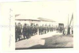Soldaten marschieren durch ein Dorf