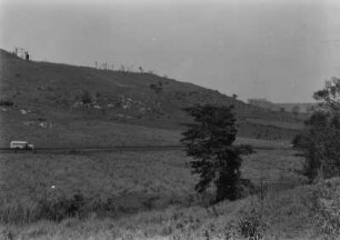 Landschaft mit Stufe : Blick in eine stufige Landschaft mit einem sumpfigen Gebiet im Vordergrund und Hügeln im Hintergrund. In der Mitte eine Straße der Bus der Expedition.