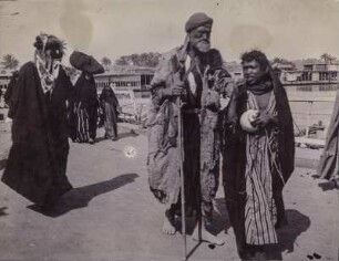 Portrait in Bagdad : Portrait eines älteren Mannesund eines Jungen auf einer Straße im Bagdad. Daneben weitere Passaten, im Hintergrund der Tigris.