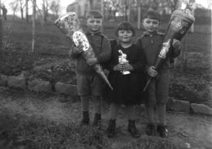 Sachsen? Schuleinführung. Drei Kinder in einem Garten stehend