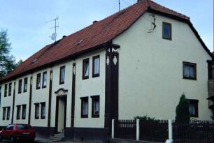 großes Haus mit Putzstuck (Girlanden) und zurückgesetzem Eingang; modernisiert