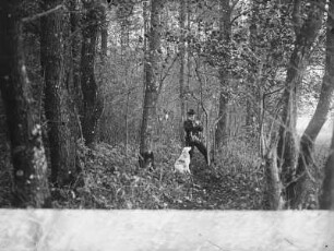 Vogelfänger mit Jagdbeute und Hund im Wald
