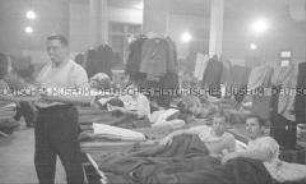 Selbstversenkung des Hochseepassagierdampfers "Columbus" am 19. Dezember 1939, Besatzungsangehörige im Internierungslager auf Ellis Island, in einfachen Feldbetten liegend, lesend, rauchend