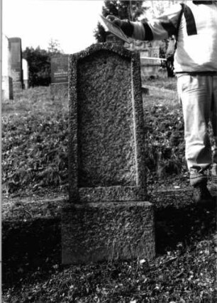 Grabstein 166 (Index: 100090475) Material: Granit Zustand: gut, Schriftplatte fehlt Maße HxBxT: 145x45x22 cm Beschreibung: konische Stele, Sockel, Konvexbogenabschluß, Schriftfeld eingetieft: Grabstein 166 (2)