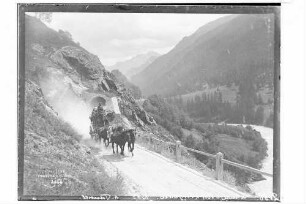 Blick auf eine Schweizer Postkutsche am Tunnel im Engadin