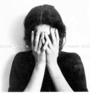 Brustbild einer Frau, die Hände vor dem Gesicht (Altersgruppe 18-21)