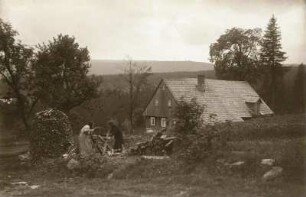Frauen beim Holzsägen : Schreiberhau-Hinterschreiberhau (heute Szlarska Poreba / Polen). Frauen beim Holzsägen vor einem alten Haus