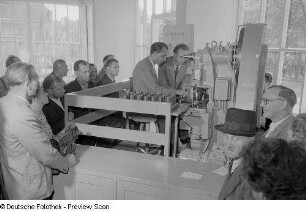 Besucher der Technischen Messe 1953 bei der Vorführung einer Nietmaschine