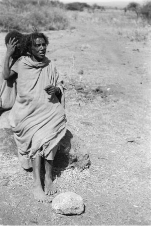Personen auf einem Stein : Zwei Personen der Arsi-Oromo sitzen auf einem Stein am Wegesrand