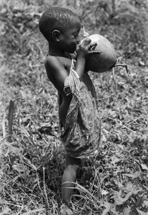 Kinderportrait : Kind, das von einer Frucht trinkt.