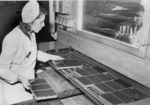 Hamburg. Geb-Schokoladenfabrik. Eine Arbeiterin nimmt Schokoladentafeln vom Band
